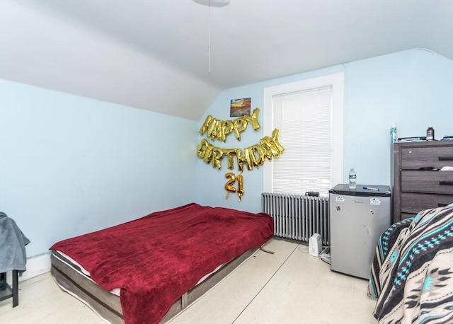 bedroom with a ceiling fan, lofted ceiling, radiator, and freestanding refrigerator