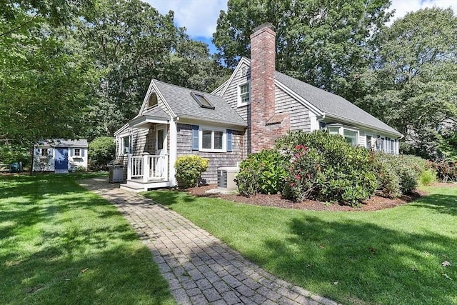 4 Wildwood Ave, Harwich, MA 02645 - view of front of house featuring a shingled roof, a front lawn, a chimney, and view of scattered trees