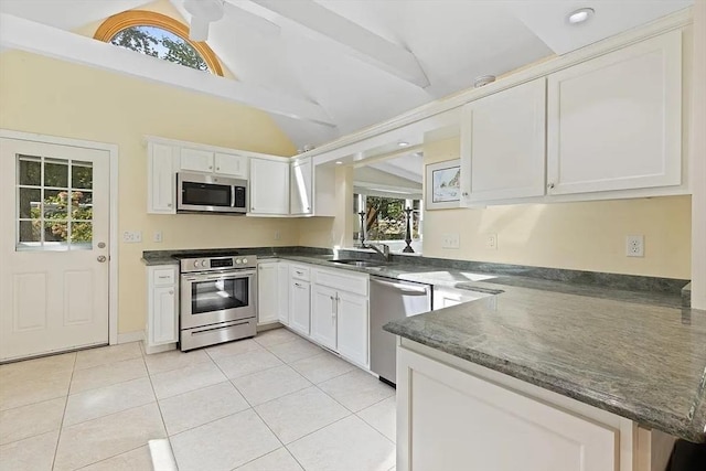 4 Wildwood Ave, Harwich, MA 02645 - kitchen featuring stainless steel appliances, a peninsula, light tile patterned flooring, white cabinets, and dark stone counters