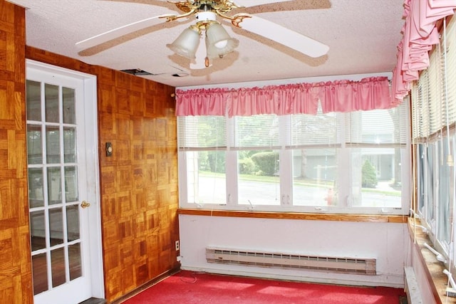 49 Newcomb Rd, Stoneham, MA 02180 - unfurnished sunroom featuring a baseboard heating unit, a textured ceiling, wood walls, radiator, and carpet flooring