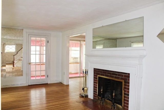 49 Newcomb Rd, Stoneham, MA 02180 - unfurnished living room with wood finished floors, a fireplace with flush hearth, stairs, plenty of natural light, and crown molding