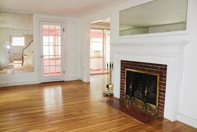 49 Newcomb Rd, Stoneham, MA 02180 - unfurnished living room with wood finished floors, a tile fireplace, crown molding, healthy amount of natural light, and stairway