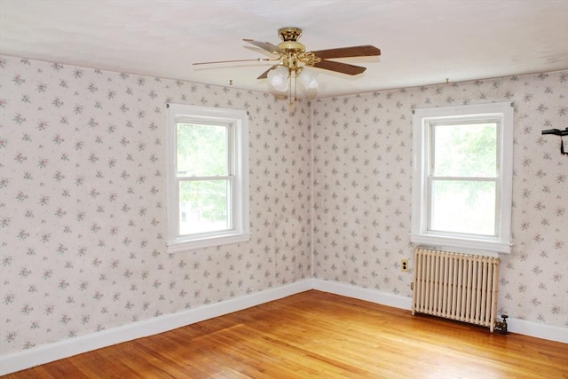 49 Newcomb Rd, Stoneham, MA 02180 - spare room featuring radiator heating unit, light wood-type flooring, plenty of natural light, and ceiling fan