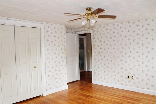 49 Newcomb Rd, Stoneham, MA 02180 - unfurnished bedroom with light wood-type flooring, wallpapered walls, a closet, and ceiling fan