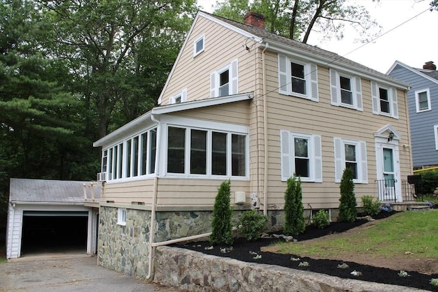 49 Newcomb Rd, Stoneham, MA 02180 - view of front of home with a chimney, concrete driveway, an attached garage, and a sunroom
