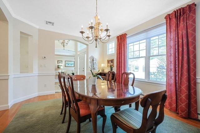 dining room featuring an inviting chandelier, hardwood / wood-style flooring, and ornamental molding