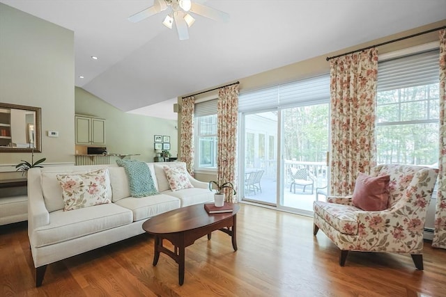 living room featuring ceiling fan, wood-type flooring, and vaulted ceiling