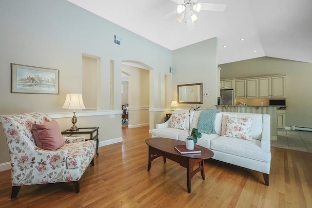 living room featuring ceiling fan, a baseboard radiator, light hardwood / wood-style floors, and vaulted ceiling