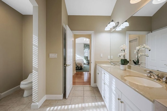 bathroom with tile patterned flooring, vanity, and toilet