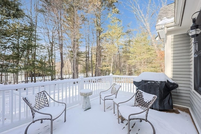 snow covered patio featuring a deck