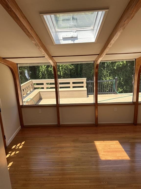 unfurnished sunroom with a skylight