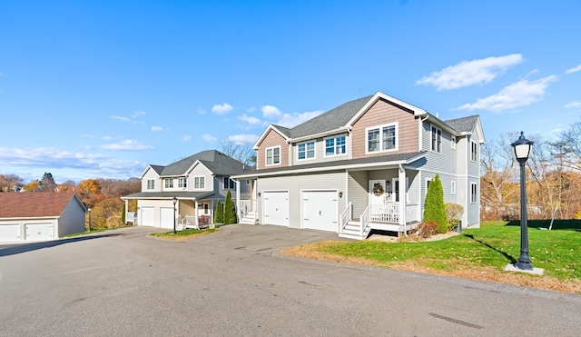 view of front of property featuring a garage, a front lawn, and a porch