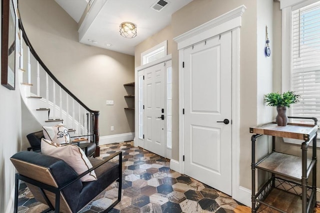 entryway featuring baseboards and stairway