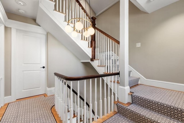 staircase featuring wood finished floors and baseboards