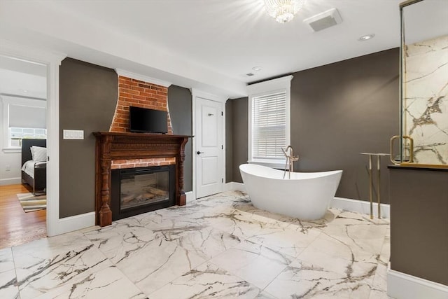 full bathroom featuring a large fireplace, a soaking tub, baseboards, marble finish flooring, and recessed lighting