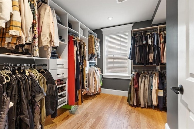 walk in closet with wood finished floors