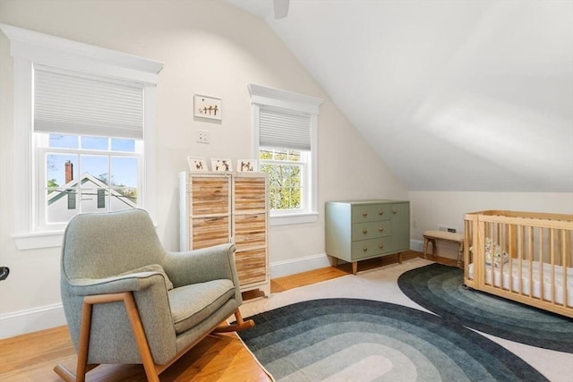 bedroom with vaulted ceiling, baseboards, wood finished floors, and ceiling fan