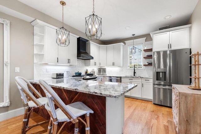 kitchen with open shelves, appliances with stainless steel finishes, wall chimney range hood, a peninsula, and recessed lighting