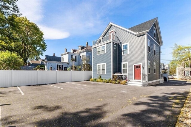 view of side of property with fence and uncovered parking