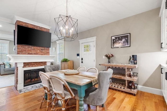 dining room with plenty of natural light, light wood finished floors, and a brick fireplace
