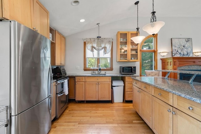 23 Hanson St, Wakefield, MA 01880 - kitchen featuring stainless steel appliances, a sink, lofted ceiling, light wood-style flooring, and light stone countertops