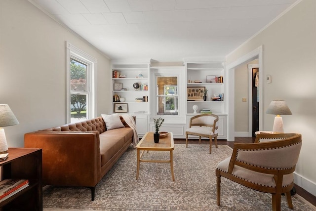 23 Hanson St, Wakefield, MA 01880 - living room featuring crown molding, built in shelves, baseboards, and wood finished floors