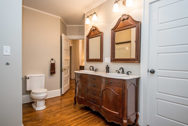 bathroom featuring vanity, toilet, wood-type flooring, and crown molding