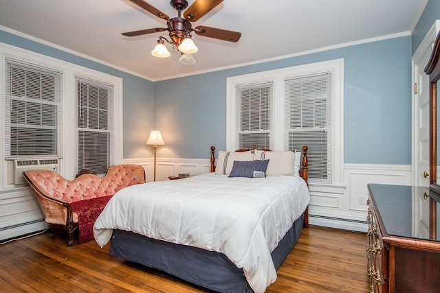 bedroom with ceiling fan, dark wood-type flooring, a baseboard heating unit, and ornamental molding