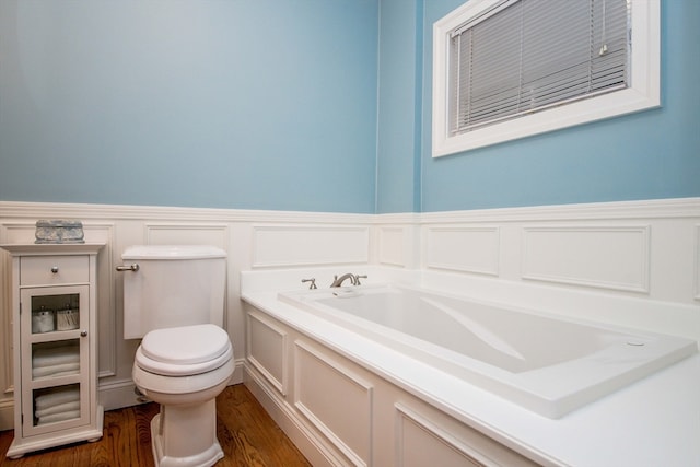 bathroom featuring a washtub, wood-type flooring, and toilet