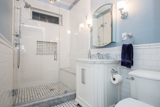 bathroom with walk in shower, vanity, toilet, and tile walls