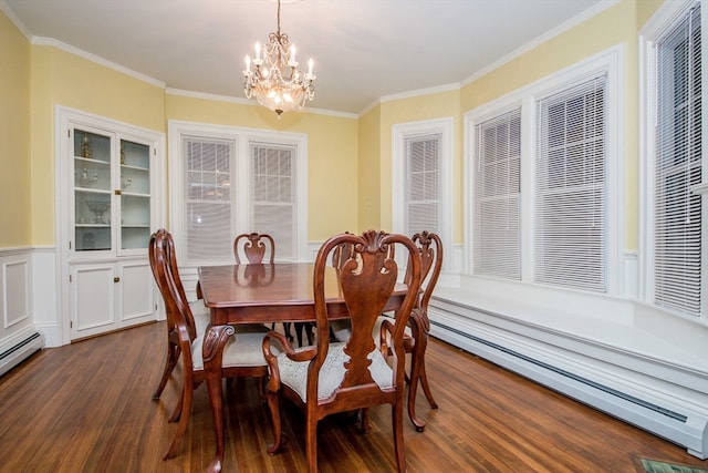 dining room featuring dark hardwood / wood-style floors, ornamental molding, baseboard heating, and an inviting chandelier