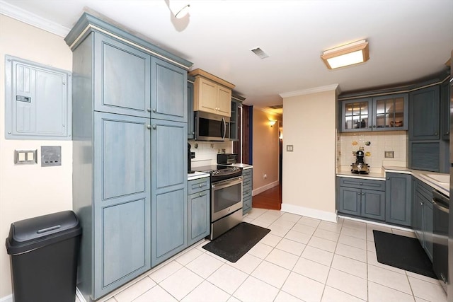 kitchen featuring backsplash, light tile patterned floors, electric panel, stainless steel appliances, and crown molding