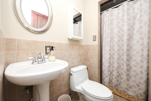 bathroom featuring walk in shower, toilet, and tile walls