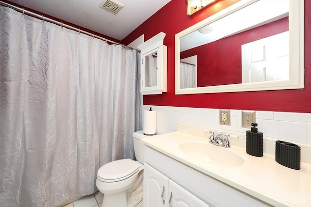 bathroom featuring vanity, tile patterned flooring, and toilet