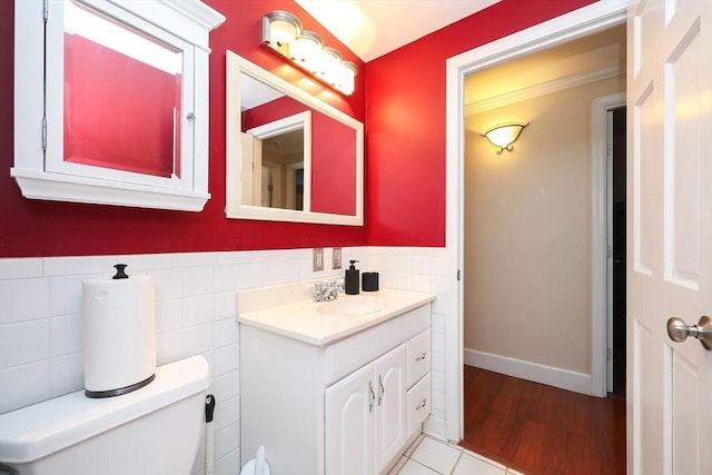 bathroom with vanity, tile walls, and toilet