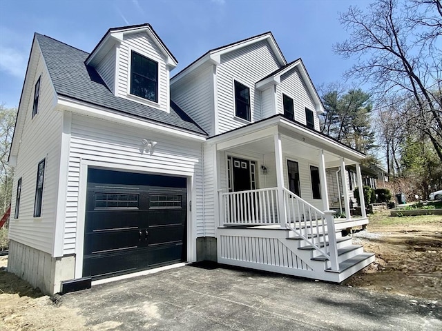 view of front of house with an attached garage, roof with shingles, covered porch, and driveway