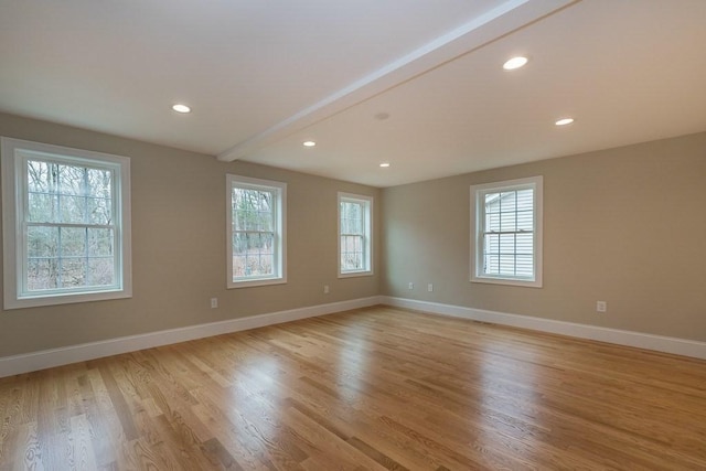 empty room with baseboards, light wood finished floors, and a healthy amount of sunlight