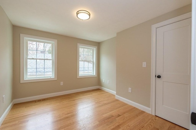 empty room featuring light wood-style floors and baseboards