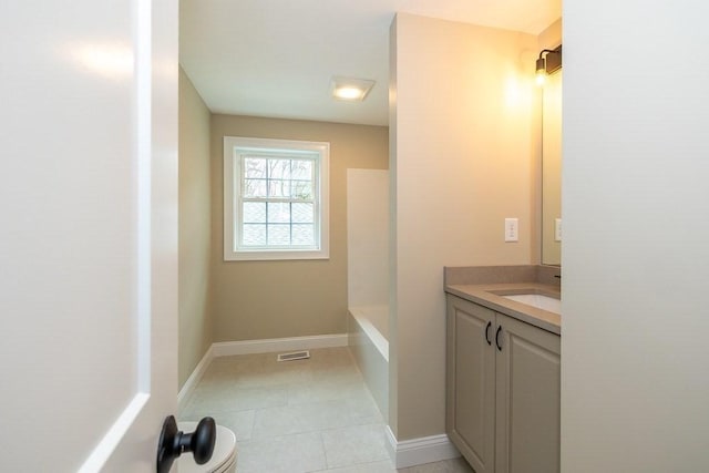 bathroom with a tub, visible vents, vanity, baseboards, and tile patterned floors
