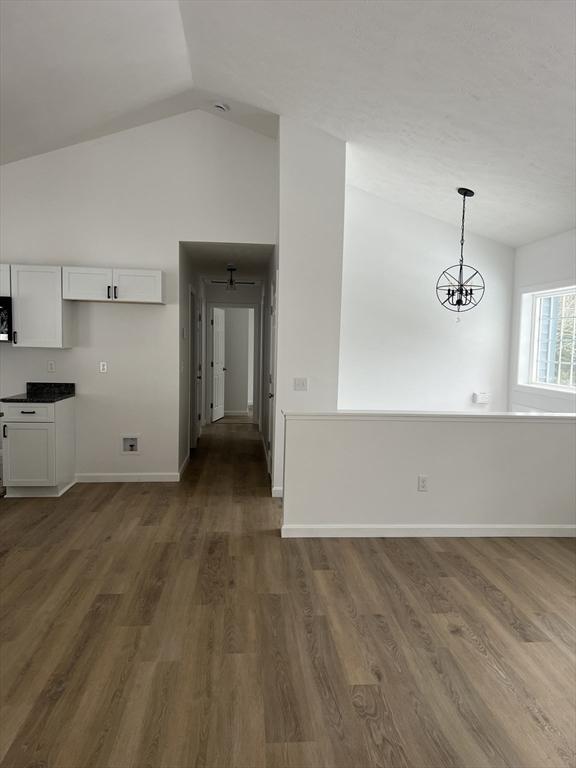 interior space with high vaulted ceiling and dark hardwood / wood-style flooring