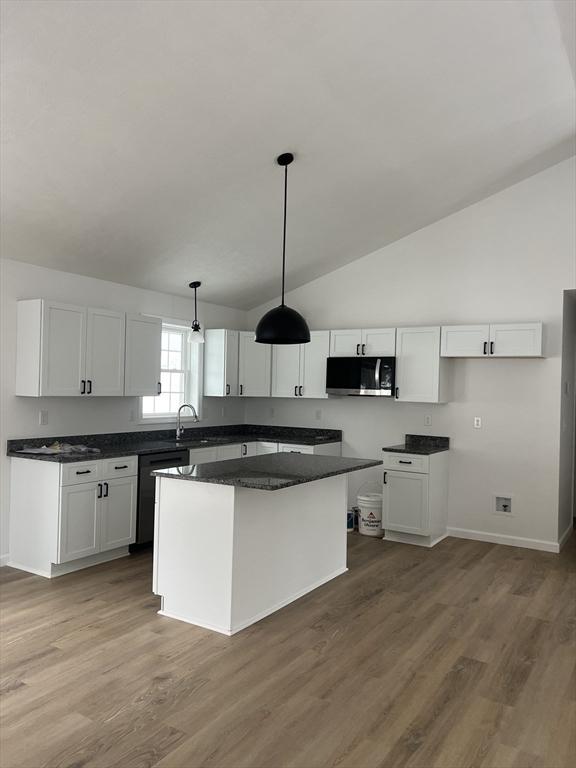 kitchen featuring black dishwasher, a center island, pendant lighting, and white cabinets