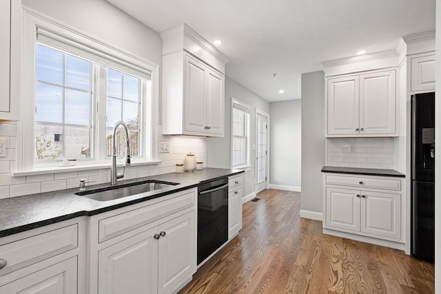 kitchen with black appliances, a sink, dark countertops, baseboards, and recessed lighting