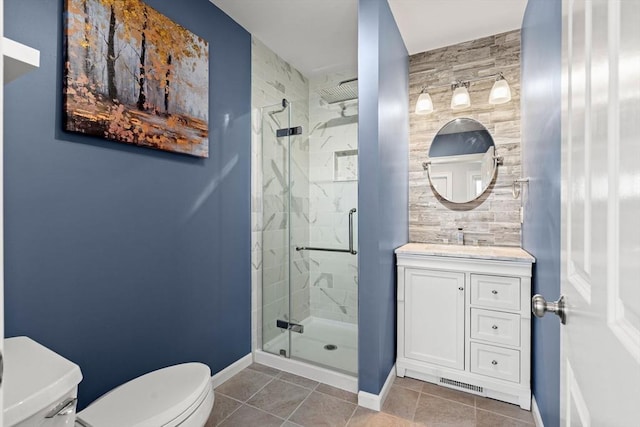 bathroom with toilet, a stall shower, tile patterned floors, baseboards, and vanity