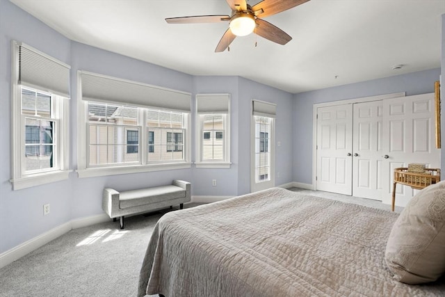 carpeted bedroom featuring baseboards, multiple windows, and a closet