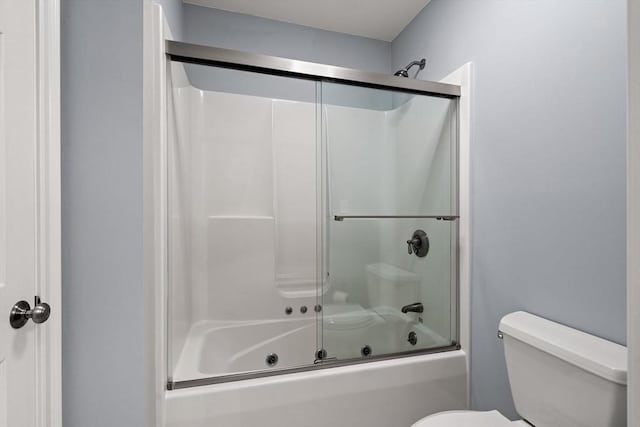 full bath featuring toilet and bath / shower combo with glass door