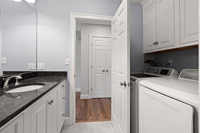 laundry room featuring washing machine and clothes dryer, baseboards, and cabinet space
