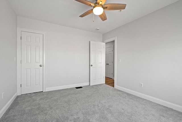 unfurnished bedroom featuring carpet, baseboards, and a ceiling fan