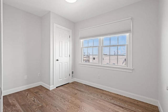 empty room featuring wood finished floors and baseboards