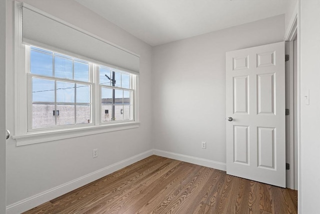 spare room featuring wood finished floors and baseboards