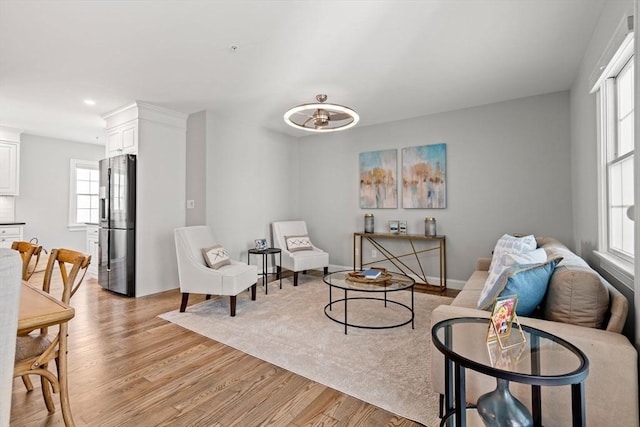 living area featuring light wood-type flooring, recessed lighting, and baseboards